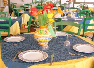 Un tavolo del ristorante pierrot adornato con i tipici piatti e colori della sicilia influenzata dalla cultura araba